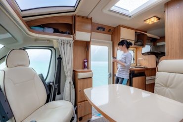 Startseite 2.0 8 | woman in the interior of a camper rv motorhome with a cup of cof Wohnmobil Sauber